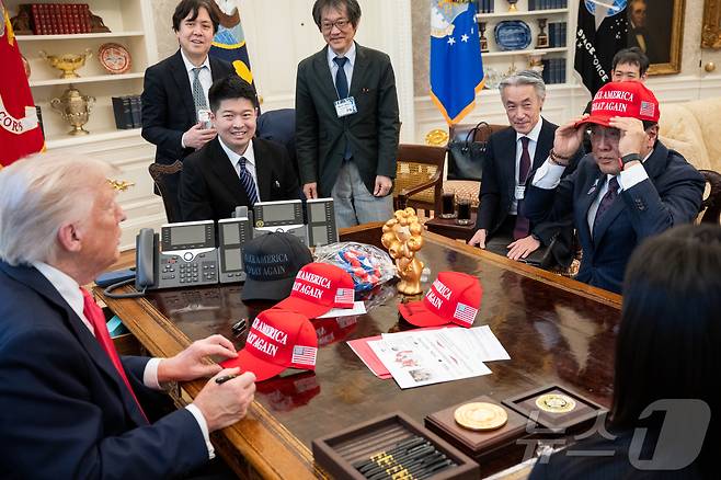 지난  4월 16일(현지시간) 미국 워싱턴DC 백악관 집무실을 찾은 아카자와 료세이 일본 경제재생상이 도널드 트럼프 미국 대통령이 서명해 건네 준 '마가(MAGA, 미국을 다시 위대하게)' 모자를 써보고 있다.(출처 백악관) ⓒ News1 류정민 특파원