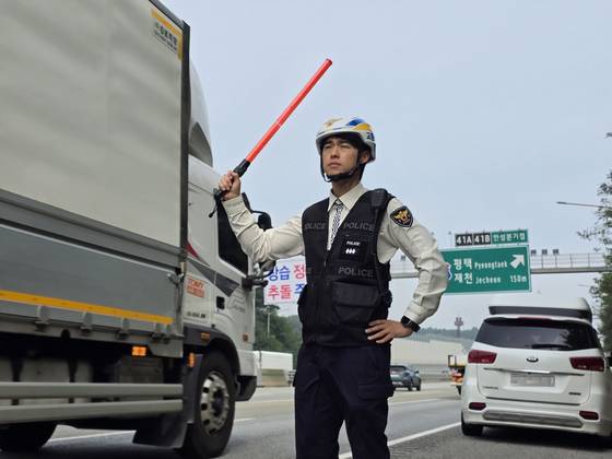 경기남부경찰청 고속도로순찰대 경찰관이 2일 오전 경부고속도로 서울방향 안성휴게소 부근에서 버스전용차로 위반 차량 단속 중 사고 예방 조치를 하고 있다. 손성배 기자