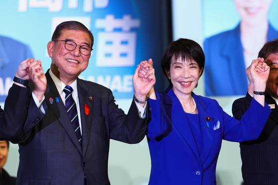 Newly-elected leader of Japan's Liberal Democratic Party (LDP) Sanae Takaichi, right, celebrates with Prime Minister Shigeru Ishiba after winning the LDP leadership election in Tokyo on Oct. 4.[AP/YONHAP]