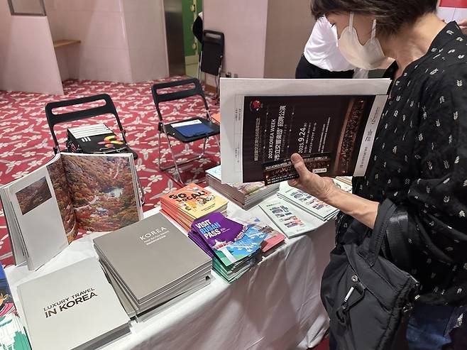 지난달 24일 일본 히로시마 JMS애스터플라자 대공연장 로비에 마련된 한국관광공사 부스에서 한 관람객이 홍보 책자를 둘러보고 있다. <사진=정수민기자>