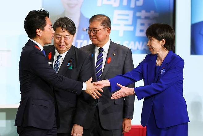 [도쿄(일본)=AP/뉴시스] 다카이치 사나에 일본 전 경제안보담당상이 4일 일본 도쿄 자유민주당 당사에서 열린 자유민주당 총재 선거에서 당선된 후 후보였던 고이즈미 신지로 농림수상상 장관과 인사를 나누고 있다. 2025.10.04.