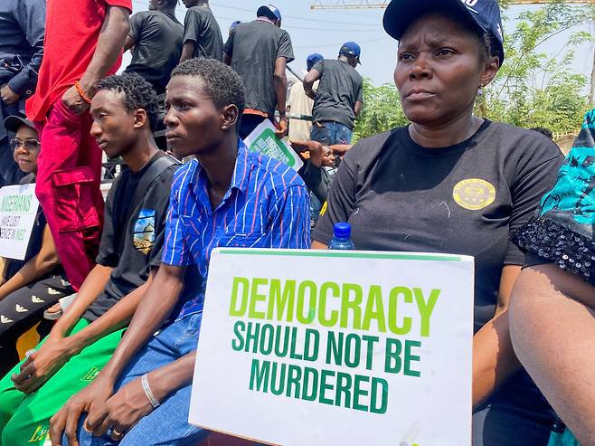 2023년 나이지리아 청년들이 수도 아부자에서 민주주의를 호소하는 집회를 하고 있다. 피켓엔 "DEMOCRACY SHOULD NOT BE MURDERED(민주주의를 죽이지 말라)"고 적혀 있다. /로이터 연합뉴스