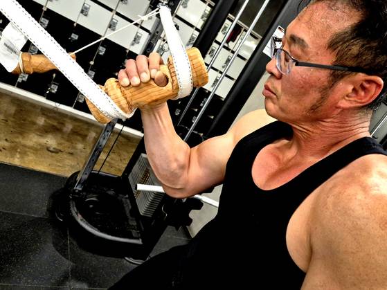 지난달 25일 경남 김해시 한 헬스장에서 팔씨름 훈련 중인 서상진(55)씨 모습. 서씨 손에 잡힌 '쿠비'란 이름의 팔씨름 훈련용 손잡이는 서씨가 직접 개발한 운동 기구다. 서씨는 김해시청 실무관으로, 지난달 불가리아에서 열린 제23회 세계팔씨름대회에 출전해 한국인 최초로 그랜드마스터(50대) 70㎏급 오른팔 부문 3위를 기록했다. 안대훈 기자