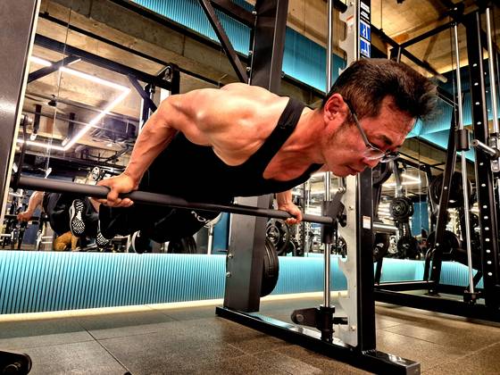 지난달 25일 경남 김해시 한 헬스장에서 팔씨름 훈련 전, '맨몸 운동 끝판왕'이라 불리는 '플란체' 동작으로 몸을 풀고 있는 서상진(55)씨 모습. 서씨는 김해시청 실무관으로, 지난달 불가리아에서 열린 제23회 세계팔씨름대회에 출전해 한국인 최초로 그랜드마스터(50대) 70㎏급 오른팔 부문 3위를 기록했다. 안대훈 기자