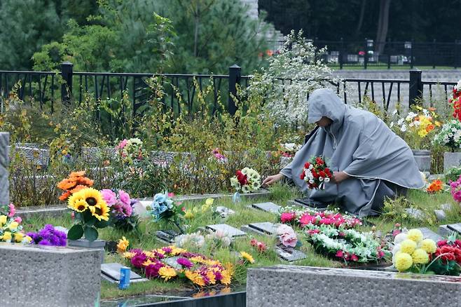 추석 명절 연휴인 지난 5일 경기도 용인시 처인구 모현읍 용인공원을 찾은 성묘객이 묘역에 꽃을 두고 있다. 뉴스1