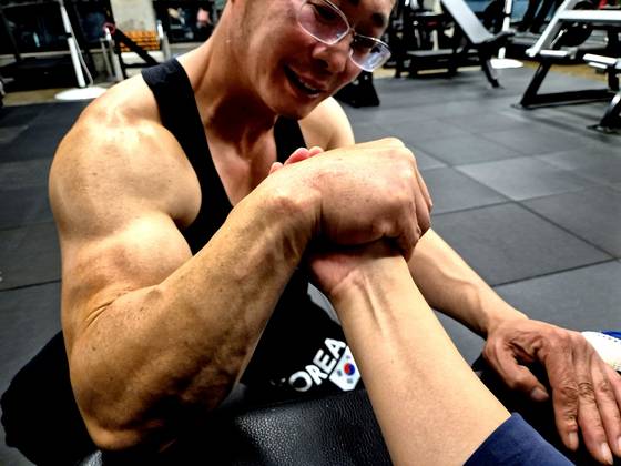 Seo Sang-jin, 55, demonstrates his arm-wrestling technique during an interview at a gym in Gimhae, South Gyeongsang, on Sept. 25. Seo became the first Korean to medal at the World Armwrestling Championships, placing third in the Grandmaster (over-50) 70-kilogram right-arm division at the 23rd competition held in Bulgaria last month. [AN DAE-HUN]