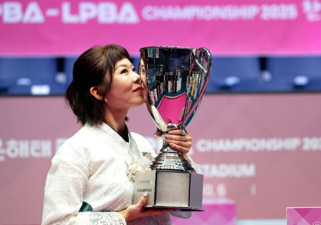 김가영이 트로피에 입을 맞추며 기념 사진을 찍고 있다./PBA