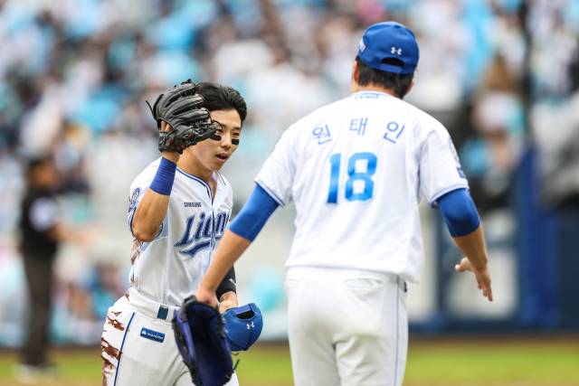 삼성 라이온즈의 우익수 김성윤이 7일 대구에서 열린 프로야구 포스트시즌 와일드카드 결정전 2차전 5회초 몸을 날려 뜬공을 잡아내며 이닝을 끝내자 선발투수 원태인이 반겨주고 있다. 삼성 제공