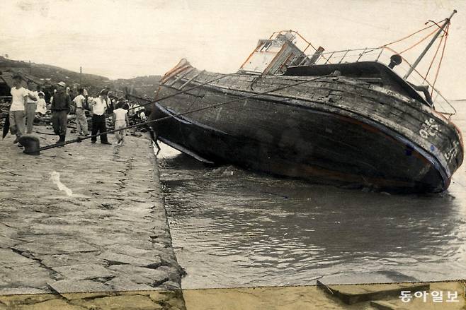 태풍 사라호가 휩쓸고 간 부산 앞바다에, 파도에 밀려온 고깃배가 위태롭게 부두에 걸쳐져 있다.  동아일보 DB