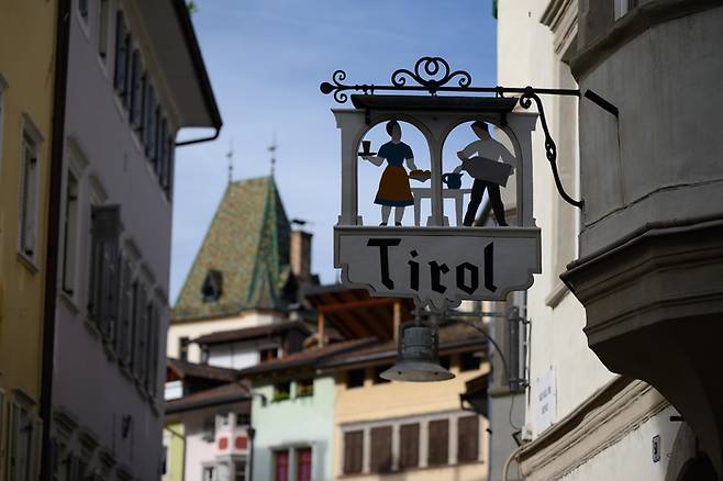 볼차노 시내의 한 가게에 걸린 티롤 표지판. 알토 아디제 지역 사람들은 스스로를 남티롤(오스트리아 인스부르크는 북티롤에 속한다)이라고 지칭한다. 티롤 표지판 너머로 인스부르크 대성당의 지붕과 같은 방식으로 만들어진 볼차노 두오모 지붕이 보인다. [사진=전형민 기자]