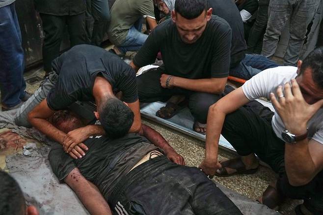 [데이르알발라=AP/뉴시스] 지난달 30일(현지 시간) 가자지구 중부 데이르알발라의 알아크사 병원에서 팔레스타인 주민들이 숨진 가족 주변에 모여 오열하고 있다. 희생자는 이스라엘의 목공소와 카페 공습 이후 병원으로 옮겨졌다. 2025.10.01.