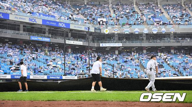 [OSEN=대구, 이석우 기자] 7일 대구 삼성라이온즈파크에서 2025 신한 SOL뱅크 KBO 와일드카드 결정전 삼성 라이온즈와 NC 다이노스의 경기가 열린다. 홈팀 삼성은 원태인이 방문팀 NC는 로건이 선발 투수로 출전한다. 갑자기 비가 내리자 관계자들이 방수포를 덮고 있다. 2025.10.07 / foto0307@osen.co.kr