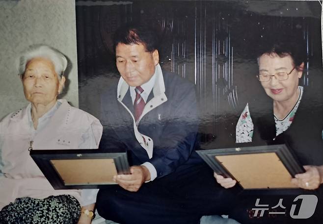 어려운 어르신들을 위해 무료로 영정사진을 인화해 전달하는 김희만 회장의 모습