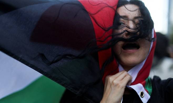 7일(현지시각) 멕시코 수도 멕시코 시티에서 머리에 팔레스타인기를 두른 한 여성이 팔레스타인 지지 집회에 참석하고 있다. 로이터 연합뉴스
