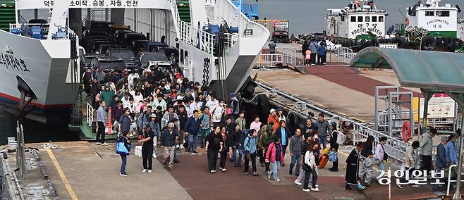 추석연휴 마지막 날인 9일 인천연안여객터미널 잔교에서 섬에 돌아오는 귀경객들이 고향의 선물을 한아름 안고 여객선을 내리고 있다. 2025.10.9 /김용국기자yong@kyeongin.com