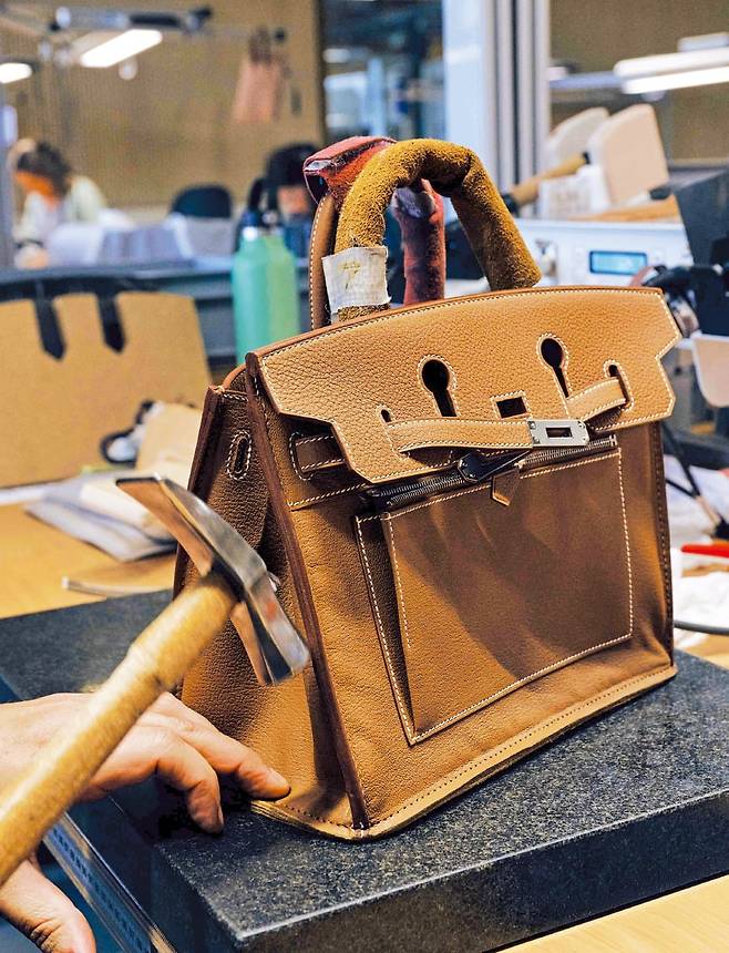 (1) 가방의 형태를 잡고 견고한 마무리를 위해 공구를 사용하는 모습.  ©Yann Stofer