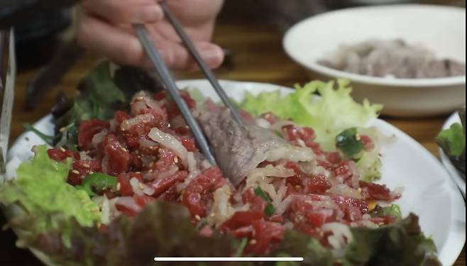 YouTuber Tzuyang tries a combination of yukhoe, or raw beef tartare, and chadolbagi, or grilled thinly sliced beef brisket, at a restaurant in Gwangjang Market. [SCREEN CAPTURE]