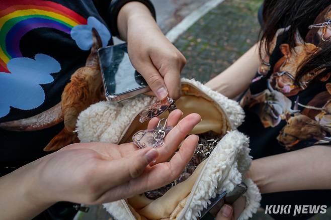 7일 경남 의령군 의령민속경기장에서 열린 ‘추석 소힘겨루기 대회’에서 정민경(24)씨가 초롱이 얼굴이 새겨진 아크릴 열쇠고리 굿즈를 받고 있다.
