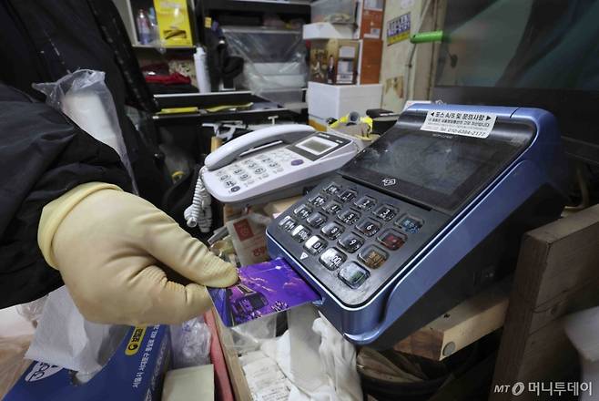 [서울=뉴시스] 김근수 기자 = 14일 서울 시내의 한 점포에서 점주가 신용카드로 물건을 결제하고 있다.