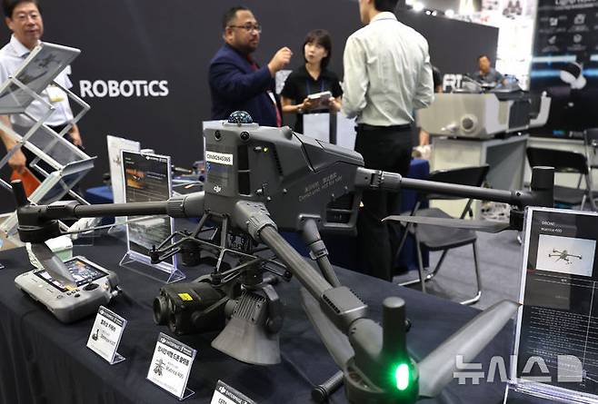 [고양=뉴시스] 전진환 기자 = 17일 오후 경기도 고양시 킨텍스에서 열린 2025 한국건설 안전박람회를 찾은 관람객이 실시간 대기오염 물질 감시 드론에 대한 설명을 듣고 있다.  2025.09.17. amin2@newsis.com