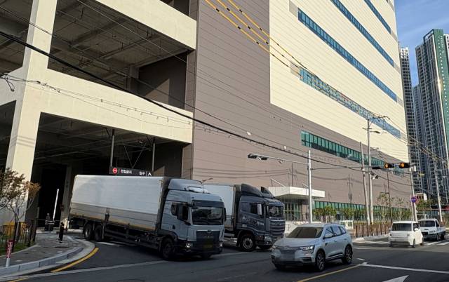 경남 김해시 안동공단 내 들어선 대형 물류센터의 진출입로가 폭 10~12m 좁은 도로와 접한 곳에 설치돼 도로를 오가는 차량들과 종종 아슬아슬한 장면을 연출한다. 이경민 기자