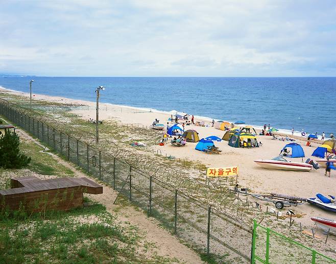 강릉 송정 해변, 낮 시간에만 출입이 가능했던 시기 여름 휴가지 철책 안에 텐트가 있는 바다풍경이 낯설다, 2012년/ 사진가 김전기