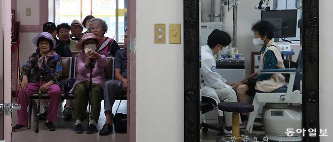 10일 오후 경북 영양군 영양병원 진료실 출입문 밖으로 고령의 환자들이 진료 차례를 기다리고 있다. 진료실 거울에는 환자를 진료하는 이상현 영양병원 원장이 비치고 있다. 서울 면적의 1.35배인 영양군엔 의사가 단 7명 있고, 전문의는 영양병원에 근무하는 단 1명이다. 영양=홍진환 기자 jean@donga.com