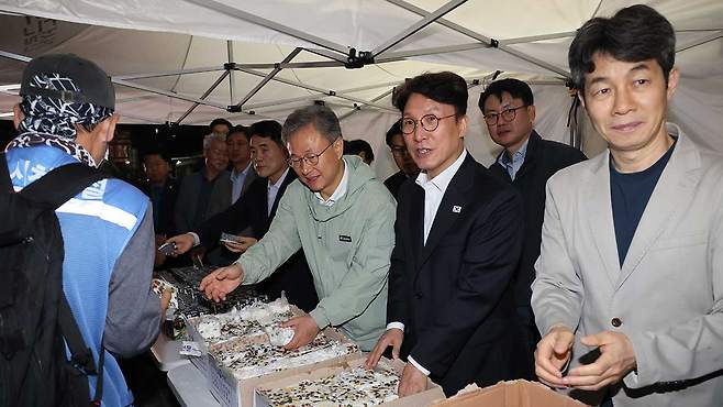김민석 국무총리가 10일 서울 구로구 남구로 새벽인력시장을 찾아 근로자들에게 떡을 나눠주고 있다.