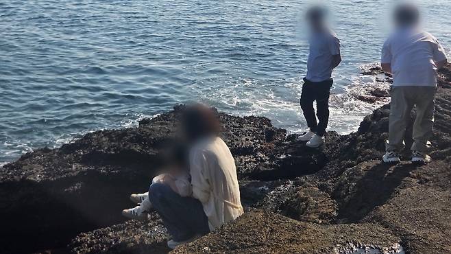 지난 추석 연휴 기간 천연기념물인 제주 용머리해안에서 한 여성이 여아 용변을 보게 하는 모습.  보배드림 갈무리.