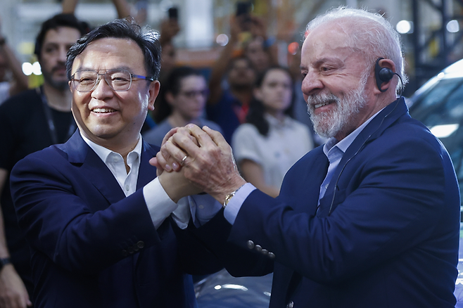 브라질 카마사리에서 열린 비야디(BYD) 전기차 공장 준공식에 참석한 루이스 이나시우 룰라 다 시우바 대통령(오른쪽)과 왕촨푸 BYD 회장이 손을 맞잡고 있다. <EPA 연합뉴스>
