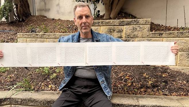 [서울=뉴시스] 2000단어가 넘는 세계에서 가장 긴 이름을 가진 로렌스 왓킨스가 자신의 이름이 적힌 종이를 펼쳐 보이고 있다. (사진출처: 기네스월드레코드 캡처) 2025.10.10.