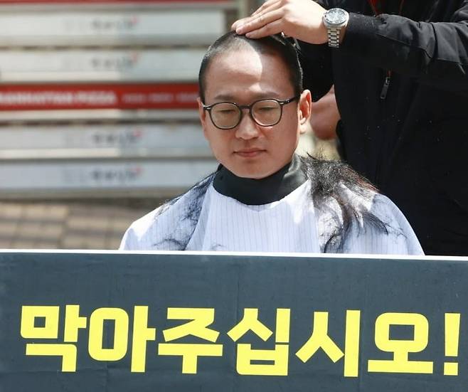 개그맨 김영민씨가 2024년 서울 여의도 국민의힘 당사 앞에서 당시 더불어민주당이 추진 중인 '전국민 1인당 민생회복지원금 25만원 지급'에 반대하며 삭발식을 하고 있다. / 사진=연합뉴스