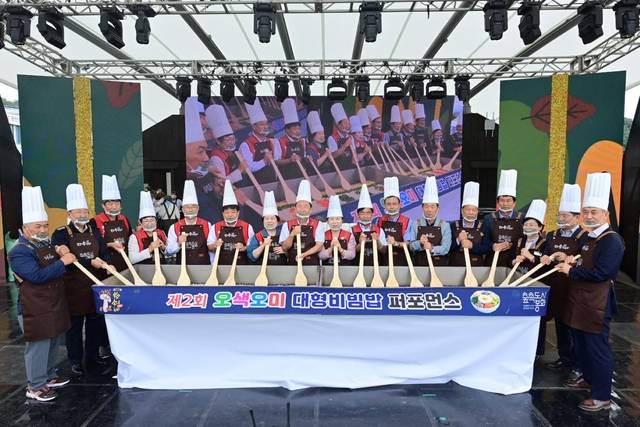 봉화송이축제 개막에 앞서 열린 '제2회 오색오미 대형 비빔밥 퍼포먼스' 현장. 참가자들이 대형 주걱을 들고 비빔밥을 함께 버무리며 축제의 서막을 열고 있다. 봉화축제관광재단 제공