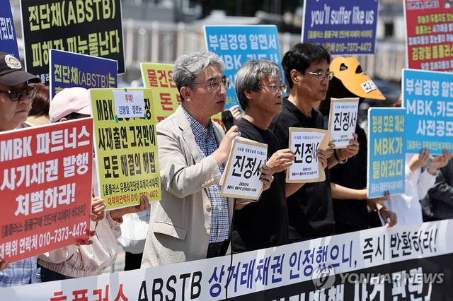 홈플러스 물품 구매 전단채 피해자 비상대책위원회 등이 지난 6월 서울 전쟁기념관 앞에서 ‘홈플러스 전단채 사기발행 사건 관련, MBK 엄벌과 피해회복을 위한 진정서 제출 기자회견’을 열고 피켓을 들고 있다. [연합뉴스 제공]