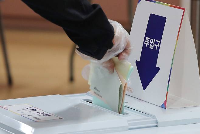 제8회 전국동시 지방선거 본 투표가 시작된 2022년 6월 1일 서울 서초구 방배1동 제1 투표소에서 유권자가 비닐장갑을 낀 채 2차 투표용지를 투표함에 넣고 있다. 총 7개 선거가 동시에 실시된 이날 투표는 유권자가 1차와 2차에 나눠 투표한 뒤 투표용지를 투표함 두 곳에 각각 넣었다. 신소영 기자 viator@hani.co.kr