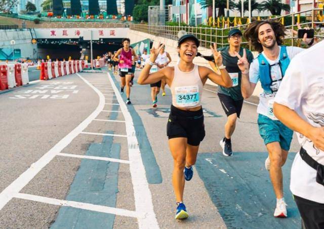 마라톤 대회 참가자들이 카메라를 향해 웃음을 지어 보이며 달리고 있다. 내일투어 제공