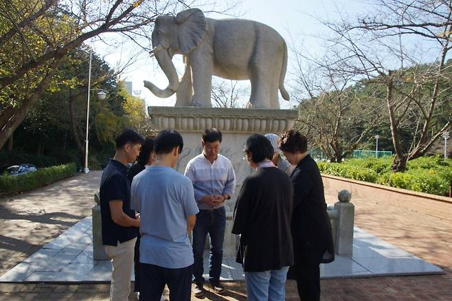 부산 영산대학교 내에 있는 코끼리상. 김경열(오른쪽 네 번째) 교수와 GOD PEOPLE 기독동아리 회원들이 캠퍼스 복음화를 위해 기도하고 있다.