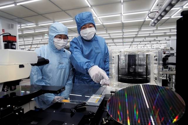 박정원(오른쪽) 두산그룹 회장이 경기도 안성 두산테스나 사업장에서 반도체 웨이퍼 테스트 과정을 살펴보고 있다. [두산 제공]