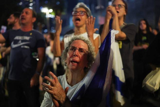 11일(현지시간) 이스라엘과 하마스 간의 휴전이 발표된 후 이스라엘 텔아비브의 '인질 광장'에 사람들이 모여 환호하고 있다. 연합뉴스