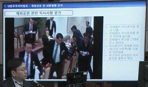 서울중앙지법 형사합의33부(부장판사 이진관) 심리로 열린 한덕수 전 국무총리 2차 공판에서 특검이 제시한 12·3 비상계엄 당일 대통령실 폐쇄회로(CC)TV 영상 화면에 비상계엄 선포 이후 윤석열 전 대통령 주재 회의가 끝나고 조태열 전 외교부 장관이 문건을 책상에 놔두고 일어서는 장면이 재생되고 있다. 특검은 재외공관 관련 지시사항이 담긴 문건이라고 설명했다. 법원 공판 중계 화면 캡처