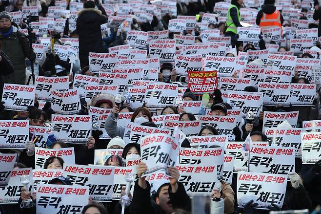 ‘12·3 내란사태’를 일으킨 내란죄 피의자 윤석열 대통령 탄핵소추안 가결 다음날인 12월15일 오후 서울 중구 서울시청 앞에 모인 시민들이 윤 대통령 체포와 헌법재판소의 파면 결정을 요구하는 내용이 담긴 손팻말을 들고 구호를 외치고 있다. 김혜윤 기자 unique@hani.co.kr