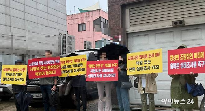 13일 성수1지구 조합 사무실 앞에서 일부 조합원들이 피켓 시위를 벌이고 있다. [사진=독자제공]