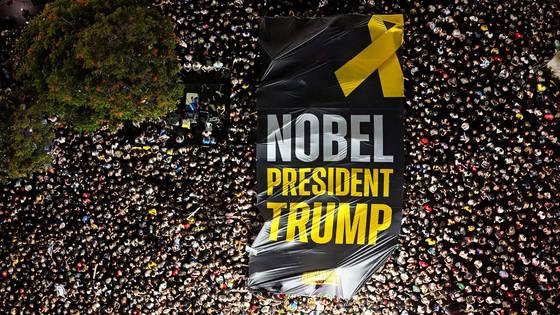 11일(현지시간) 이스라엘 텔아비브의 인질 광장(Hostages Square)에 인파가 모여 '노벨 대통령 트럼프'라고 적힌 대형 플래카드를 들어 올리고 있다. 로이터=연합뉴스