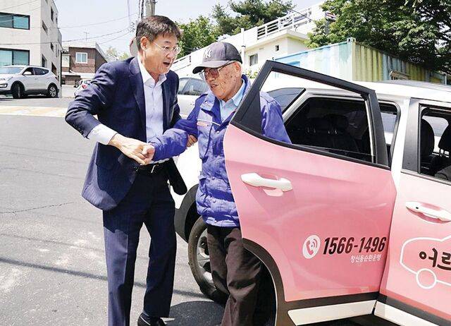 최근 서울 자치구들은 시민 편의를 위해 대중교통이 다니지 않는 지역을 누비는 공공버스를 경쟁적으로 도입하고 있다. 정문헌 종로구청장이 지난해 5월 지역 노인이 어르신 돌봄카에서 내리는 것을 돕고 있는 모습. 종로구 제공