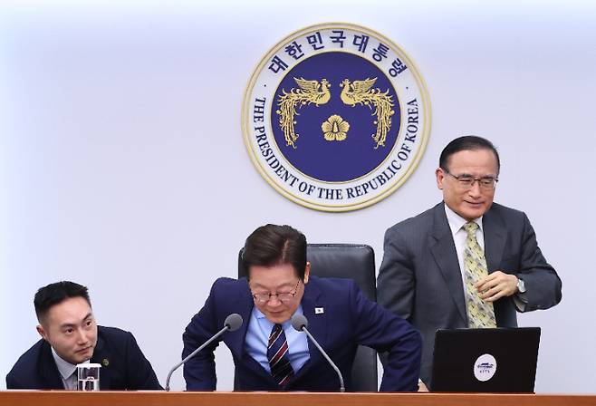 위성락 국가안보실장이 2일 용산 대통령실에서 열린 수석보좌관회의에서 이재명 대통령의 의자 높이 조절이 제대로 되지 않자 이를 도와준 뒤 자리로 돌아가고 있다. 연합뉴스