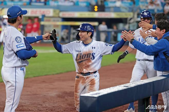 삼성 김지찬(가운데)이 13일 대구 SSG와 준PO 3차전에서 SSG의 실책을 틈타 홈을 밟은 뒤 기뻐하고 있다. 대구｜뉴시스