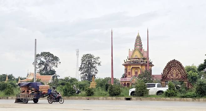 14일(현지시간) 오후 캄보디아 수도 프놈펜 인근 도로에서 차량들이 달리고 있다. 연합뉴스