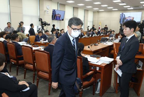 황인수 진실화해를위한과거사정리위원회 조사1국장이 14일 서울 여의도 국회에서 열린 행정안전위원회의 행정안전부 등 국정감사에서 마스크 탈착 요구를 거부한 뒤 퇴장 당하고 있다. 뉴시스