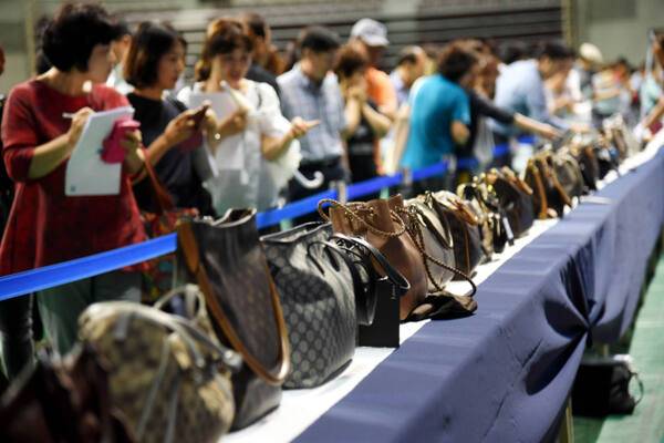 ‘지방세 체납자 압류 동산 공매’에 참여한 입찰자들이 명품가방, 시계, 귀금속 등을 살펴보고 있다. 경기일보DB