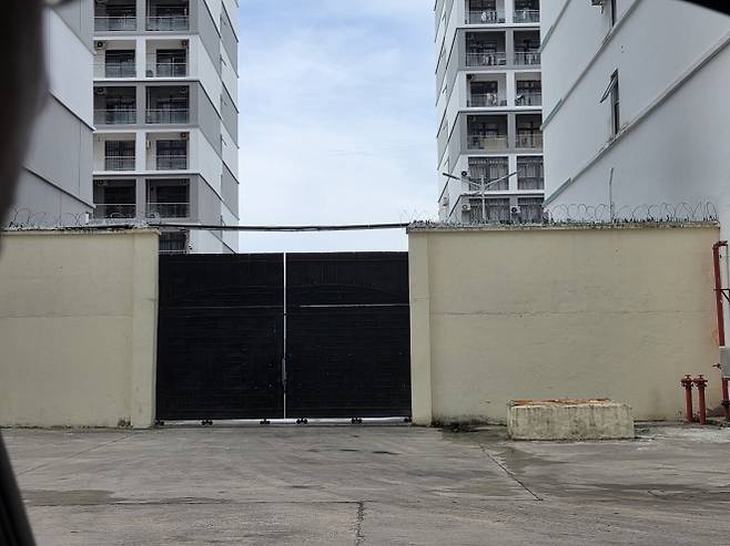 돌담 위에 설치한 철조망과 깨진 유리조각 - 14일(현지시간) 오후 캄보디아 시하누크빌에 있는 범죄 단지로 추정되는 건물 인근에 철조망과 깨진 유리조각을 설치한 담벼락이 들어서 있다. 2025.10.14 연합뉴스